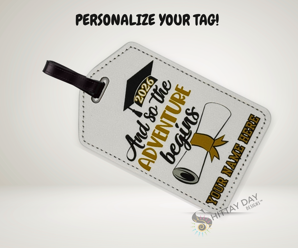 Luggage tag with graduation design and "so the adventure begins 2026" text with a name customization option on a white background.