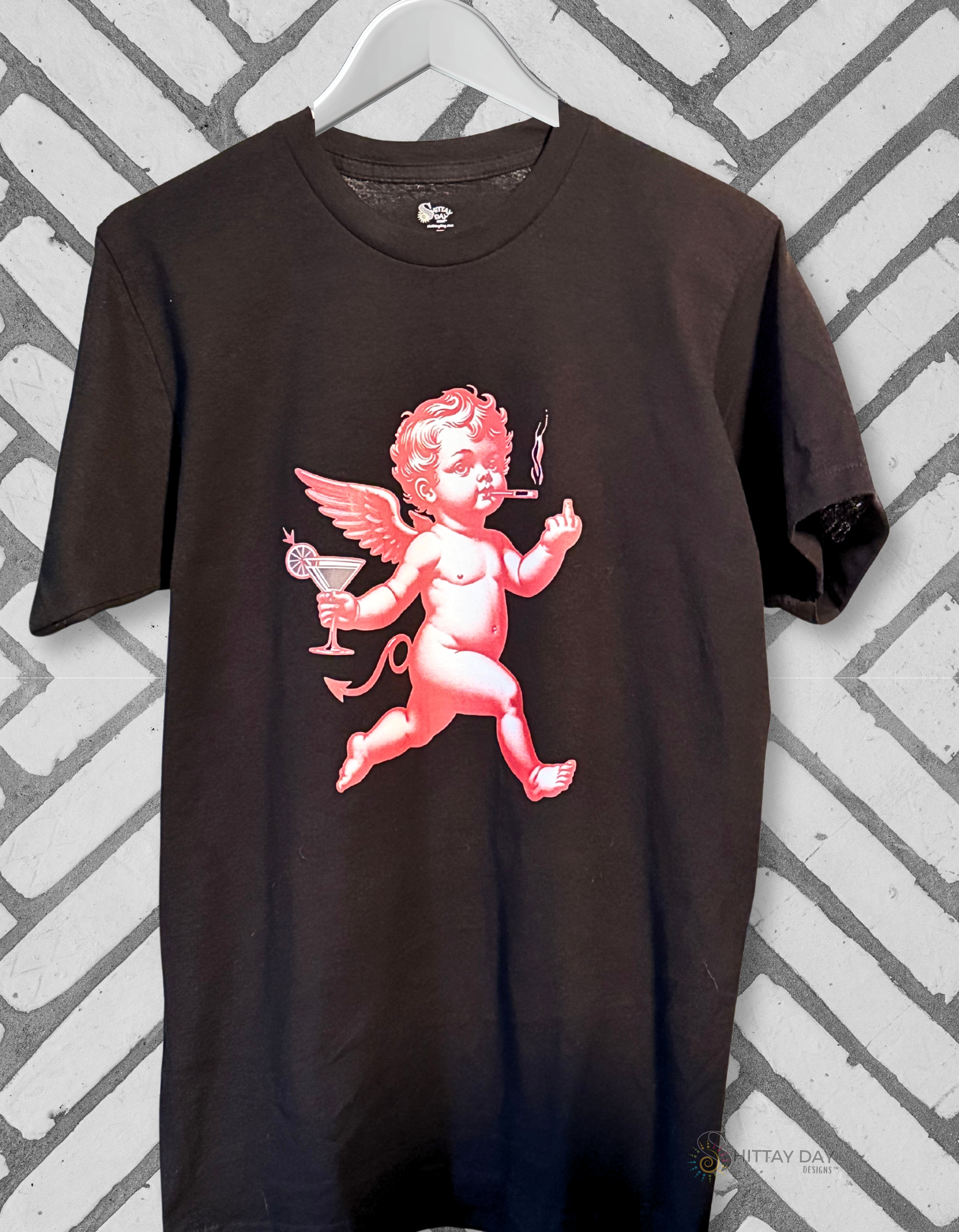 Black t-shirt with a red cherub smoking a cigarette, holding a martini glass, and flashing a middle finger design on a blue background.