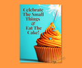 An aluminum keepsake greeting card with a cupcake with orange frosting and a lit candle on a bright blue background with text 'Celebrate The Small Things & Eat The Cake!' merchandised against an orange background.