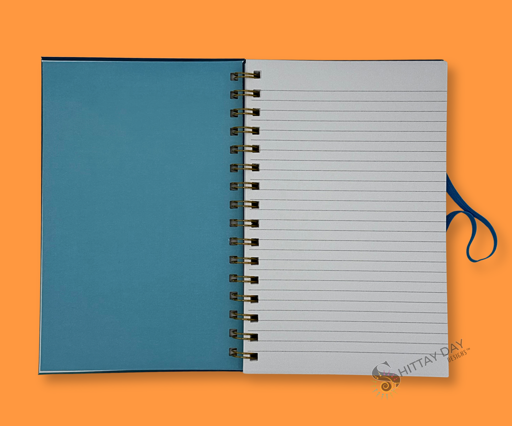 Opened wire bound notebook with blue inside cover and gray lined pages on an orange background