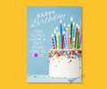 Aluminum keepsake greeting Birthday card with colorful cake and candles on and the sassy text "Happy Birthday, you don't look a day over fine as fuck". pictured on a yellow background.