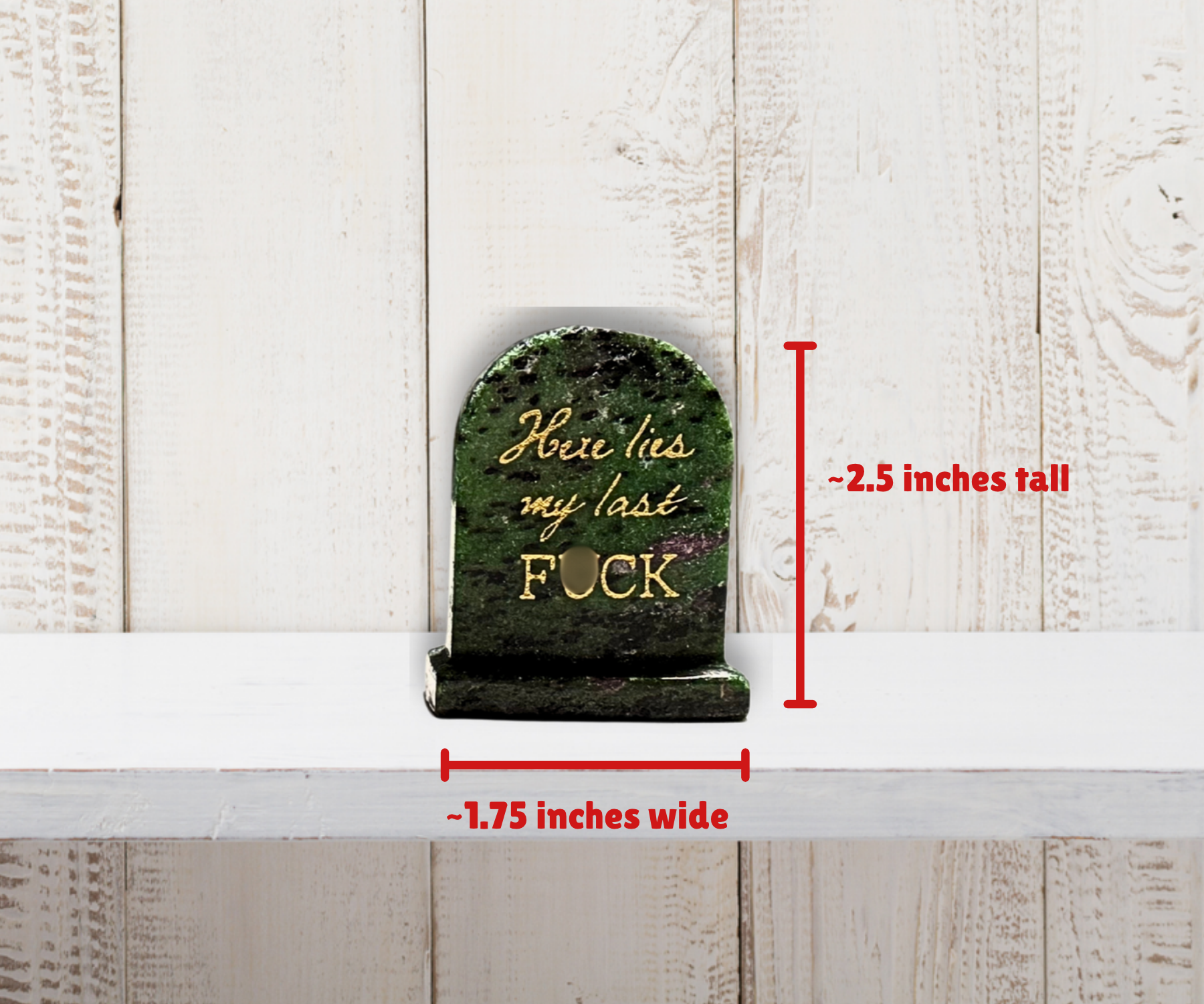 Natural crystal “Here lies my last F*CK” tombstone shown beside a size reference, approximately 6 cm tall.
