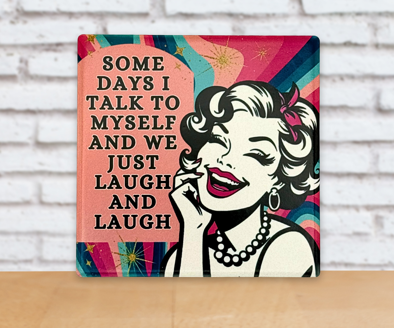 Decorative multicolor ceramic coaster with a stylized illustration of a woman smiling and the funny quote 'SomeDays I Talk To Myself And we Just Laugh And Laugh' on a colorful background.