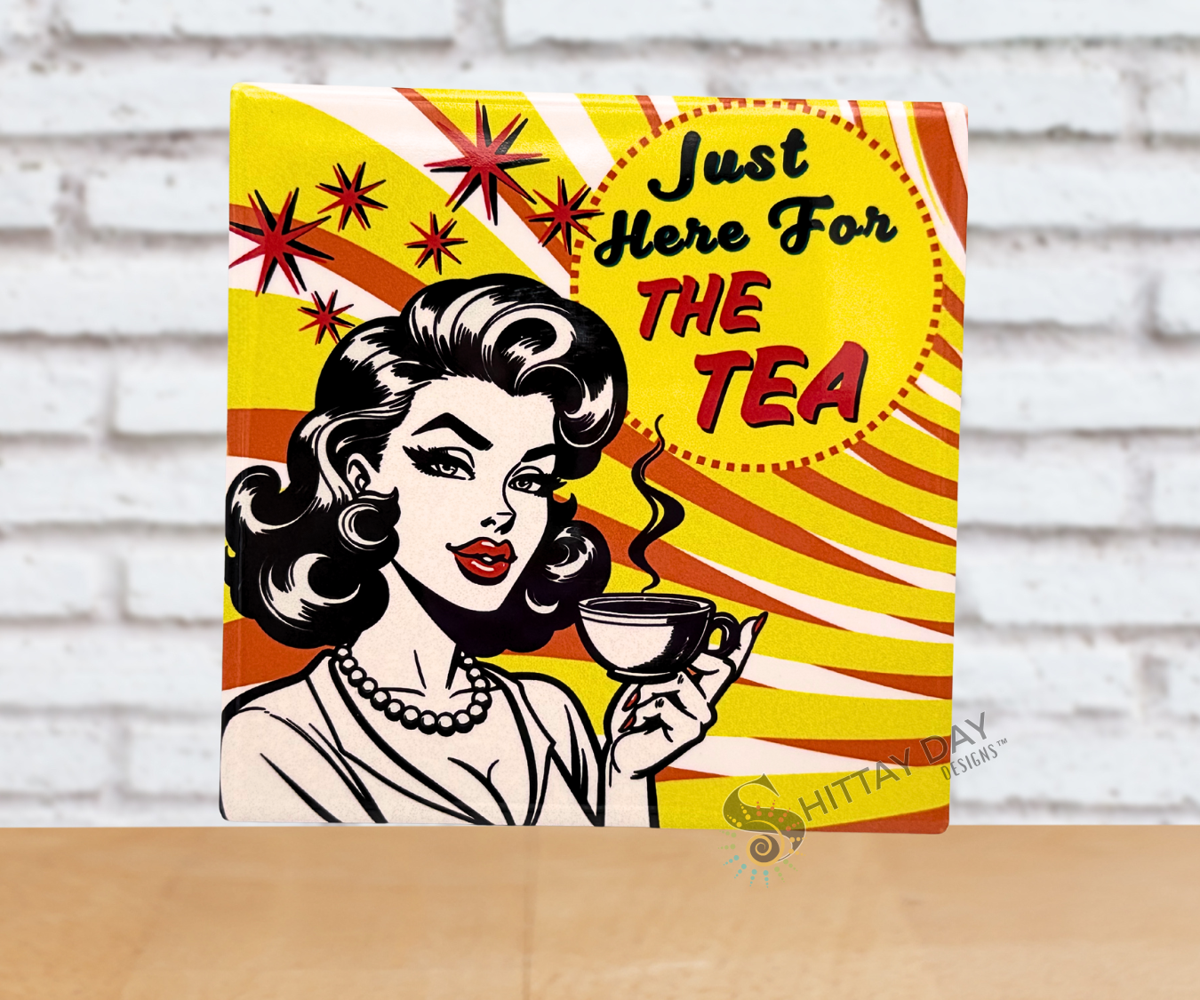 Pop culture style ceramic coaster with a retro-style illustration of a woman holding a tea cup and the sassy text 'Just Here For The Tea' on a vivid yellow, orange, and white background.