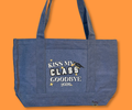 Blue denim pocket tote graduation design with 'Kiss My Class Goodbye 2026' text and graduation cap design merchandised on an orange background.