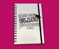 Notebook with 'Kiss My Class Goodbye 2026' bold letter text on a pinstriped. the notebook is wire bound and shows a black elastic band closure. The image is featured on a bright pink background.