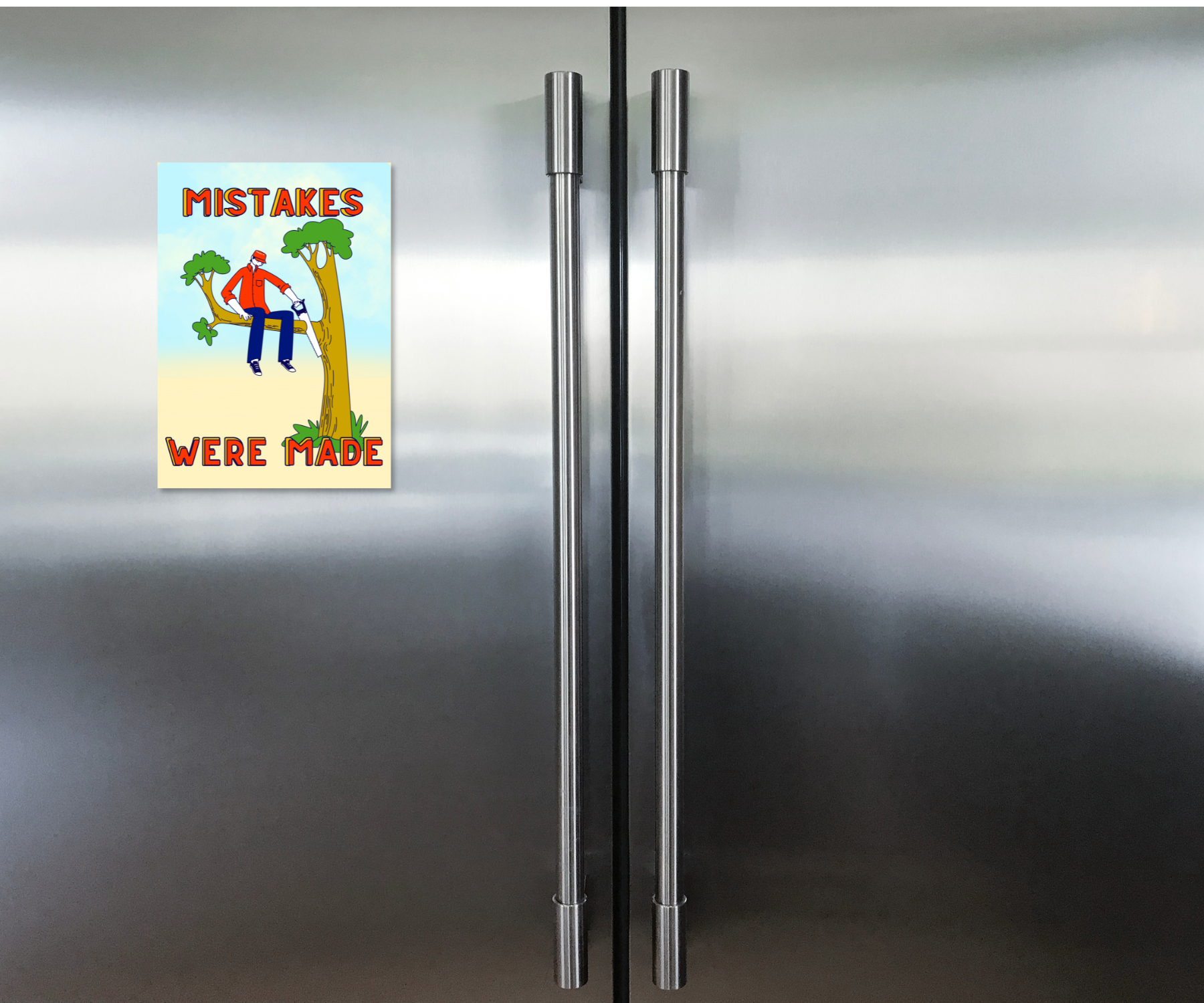 Fridge with a humorous aluminum Cardsign keepsake greeting card with cartoon depictions on character on a tree branch sawing it and text  'Mistakes Were Made'.