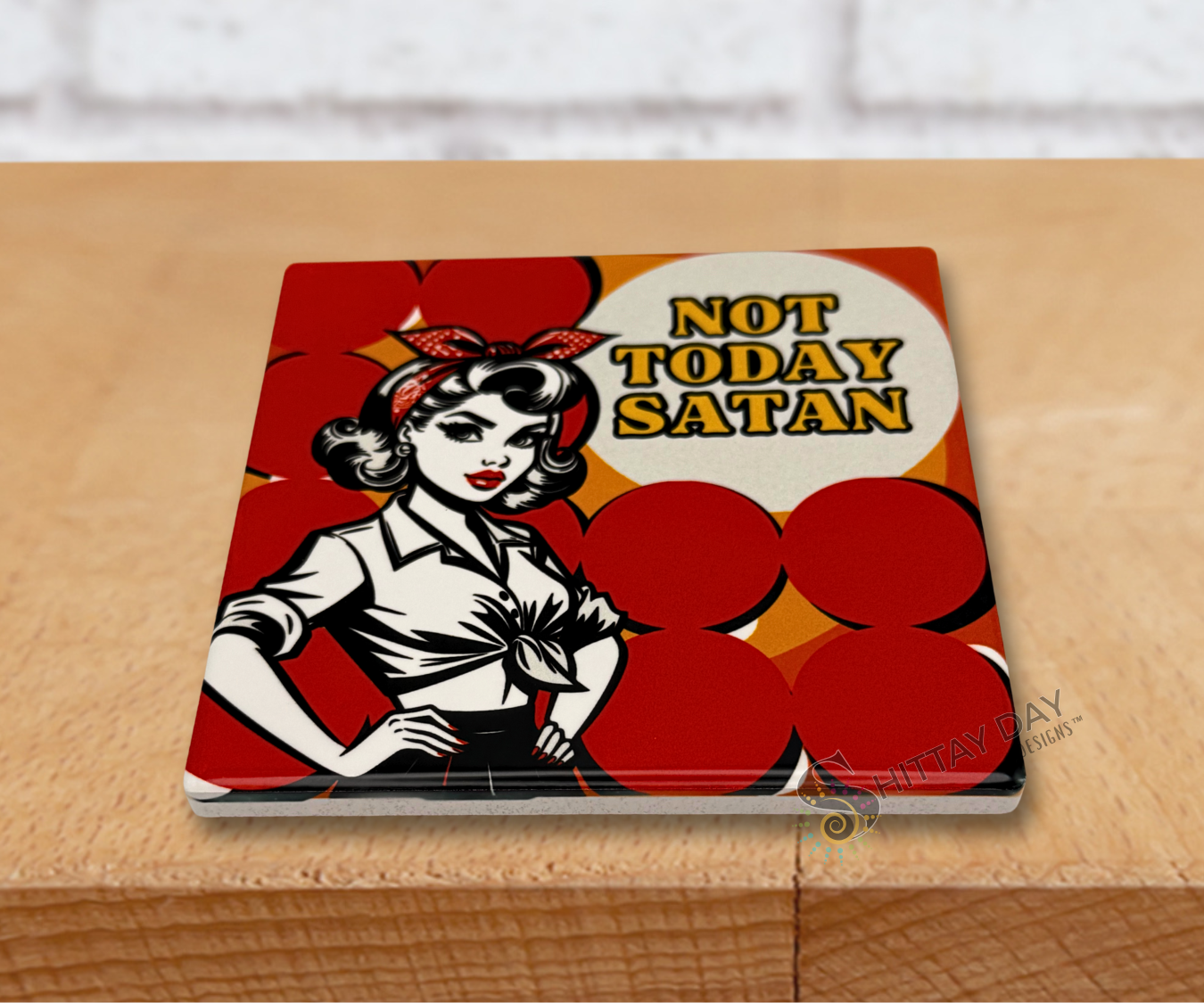 Ceramic coaster with a graphic illustration of a woman and the words 'Not Today Satan' text on a red background.
