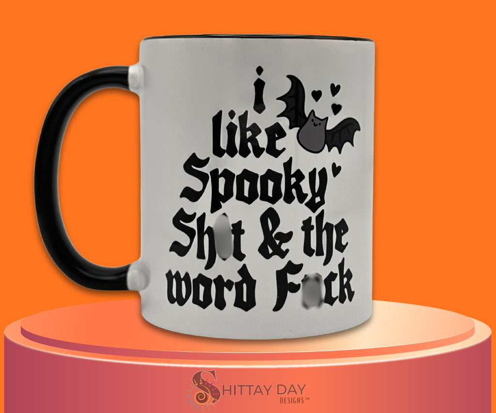 I Like Spooky Sh*t & the Word F*ck two-tone ceramic mug featuring spooky bat and heart artwork with the phrase printed clearly. Mug by Shittay Day Designs.
